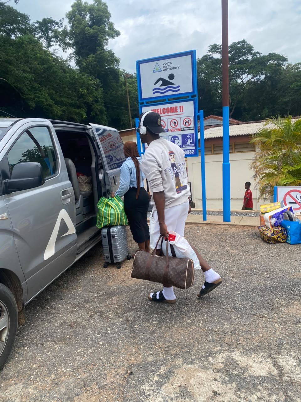Traveler loading luggage into an Allons van at the Volta River Authority