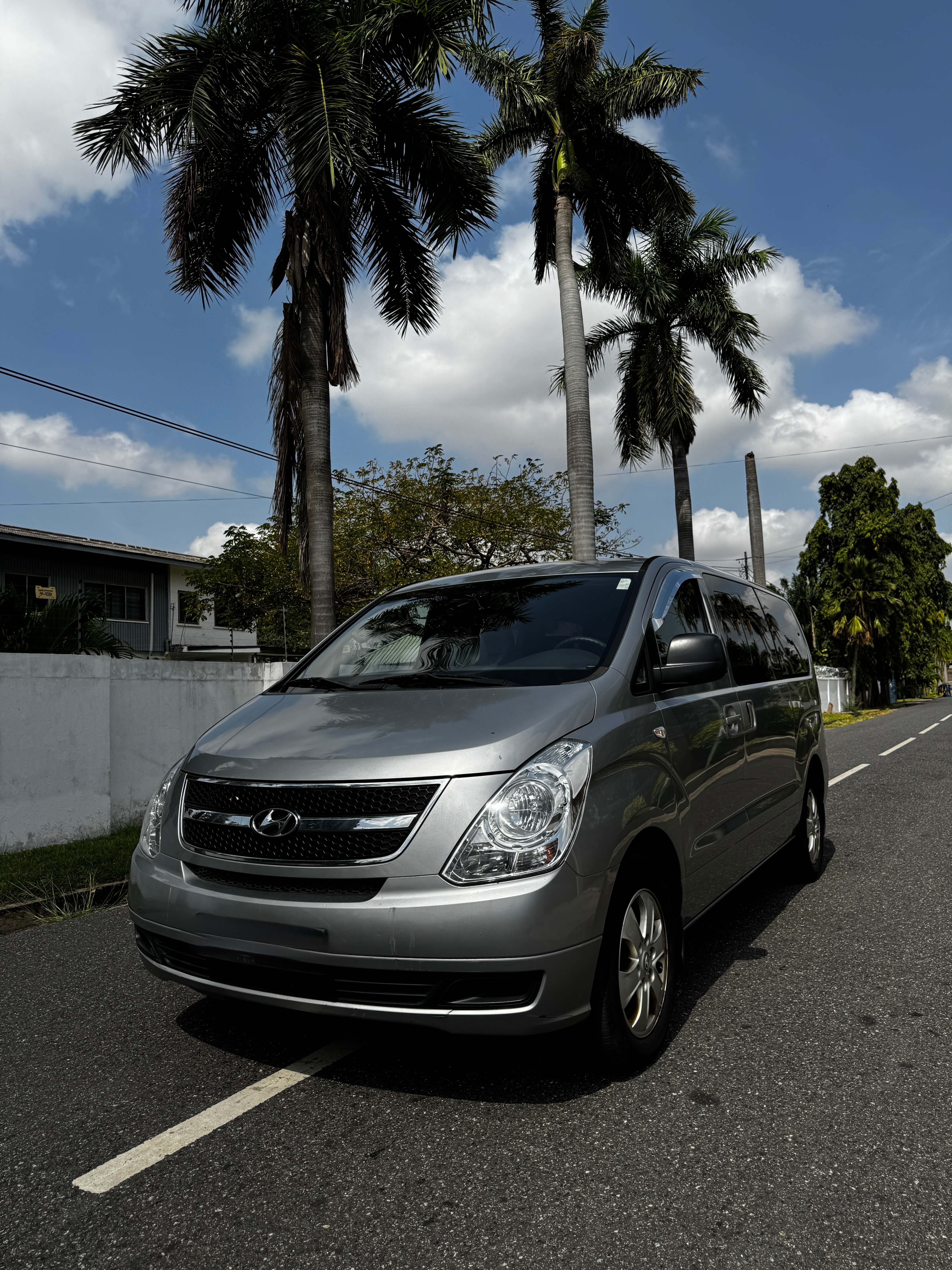 The actual Allons van you'll ride in, parked on a palm-lined street in Ghana